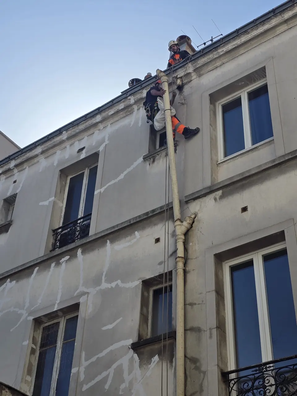 Cordistes en intervention sur un conduit de façade, immeuble parisien